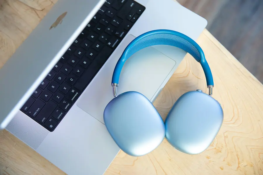 Headphones resting on a laptop on a wooden desk